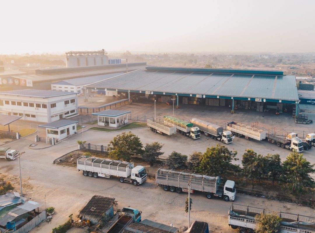 Aerial shot of factory trucks parked near the warehouse at daytime